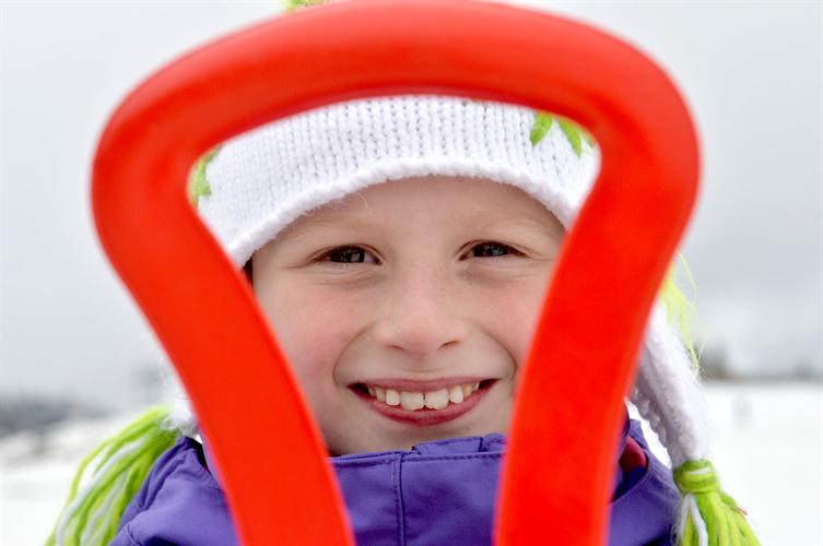 Lou-Anne regarde de très près sa luge avant de s’élancer sur les pistes de Chamonix !