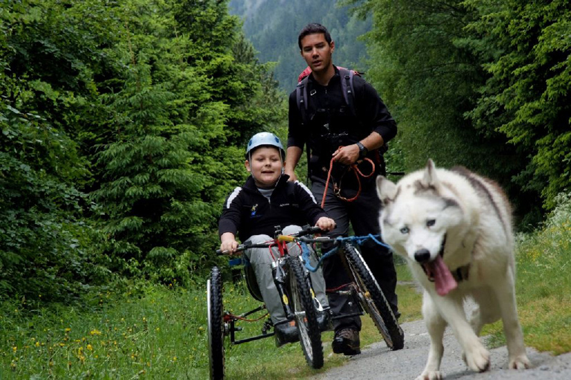 Tout sourire sur son engin à trois roues, Dylan, suivi par Jérôme.