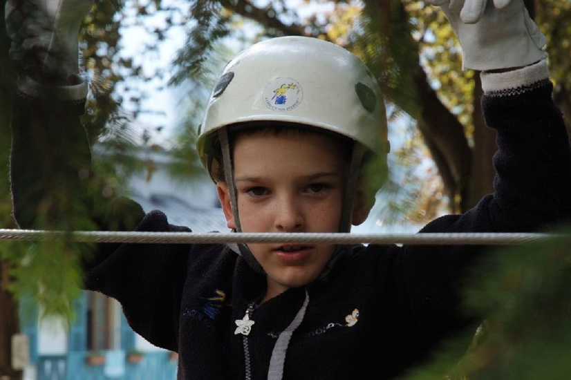 Saisi en pleine lumière au sommet des arbres, le regard concentré de Corentin
