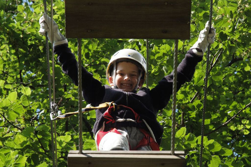 Sur fond de feuillage vert et touffu, le doux sourire de Corentin