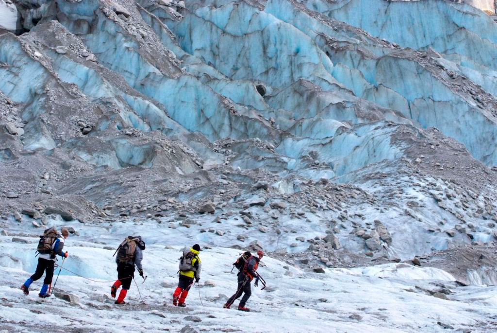 Avec en arrière plan, les strates bleutées du glacier, la cordée de Pierre…