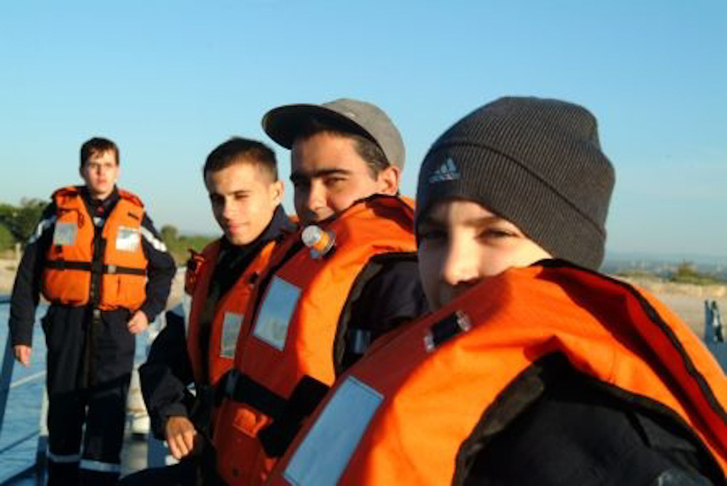Sous l’œil amusé des marins installés sur le pont…